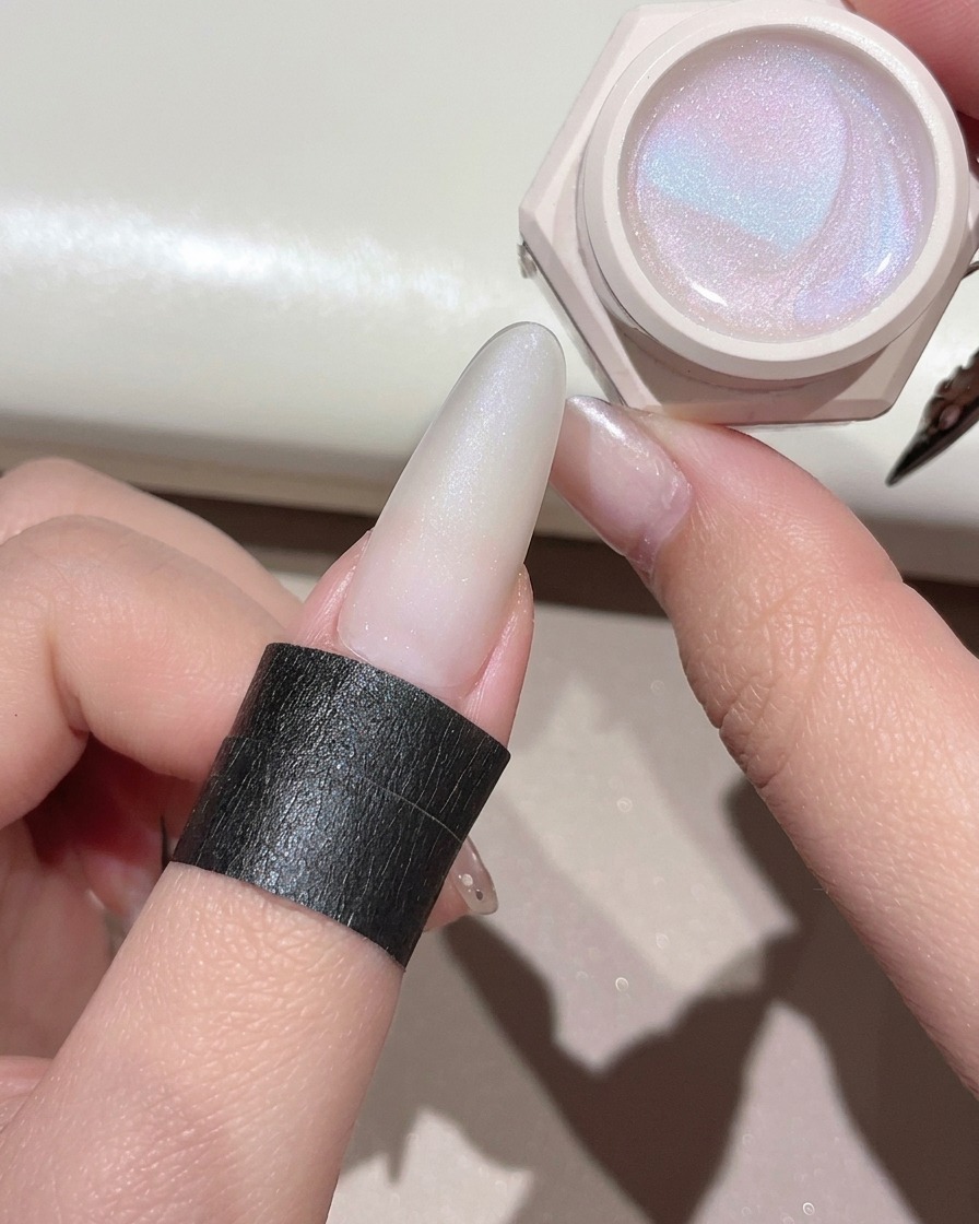 Un pincel para gel aplicando un gel ojo de gato transparente y brillante sobre la uña preparada.