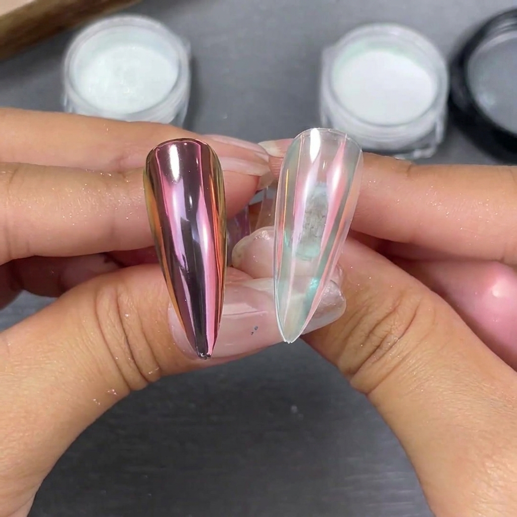 Dos puntas de uñas stiletto sostenidas lado a lado que muestran los efectos del polvo moonlight: un cambio rosado-púrpura en base negra y un suave brillo perlado en base transparente.