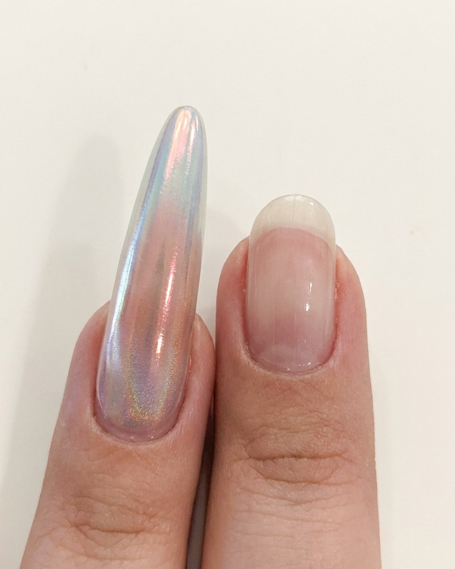 Una mano posicionada cerca de una lámpara UV/LED para curar la aplicación de la uña.