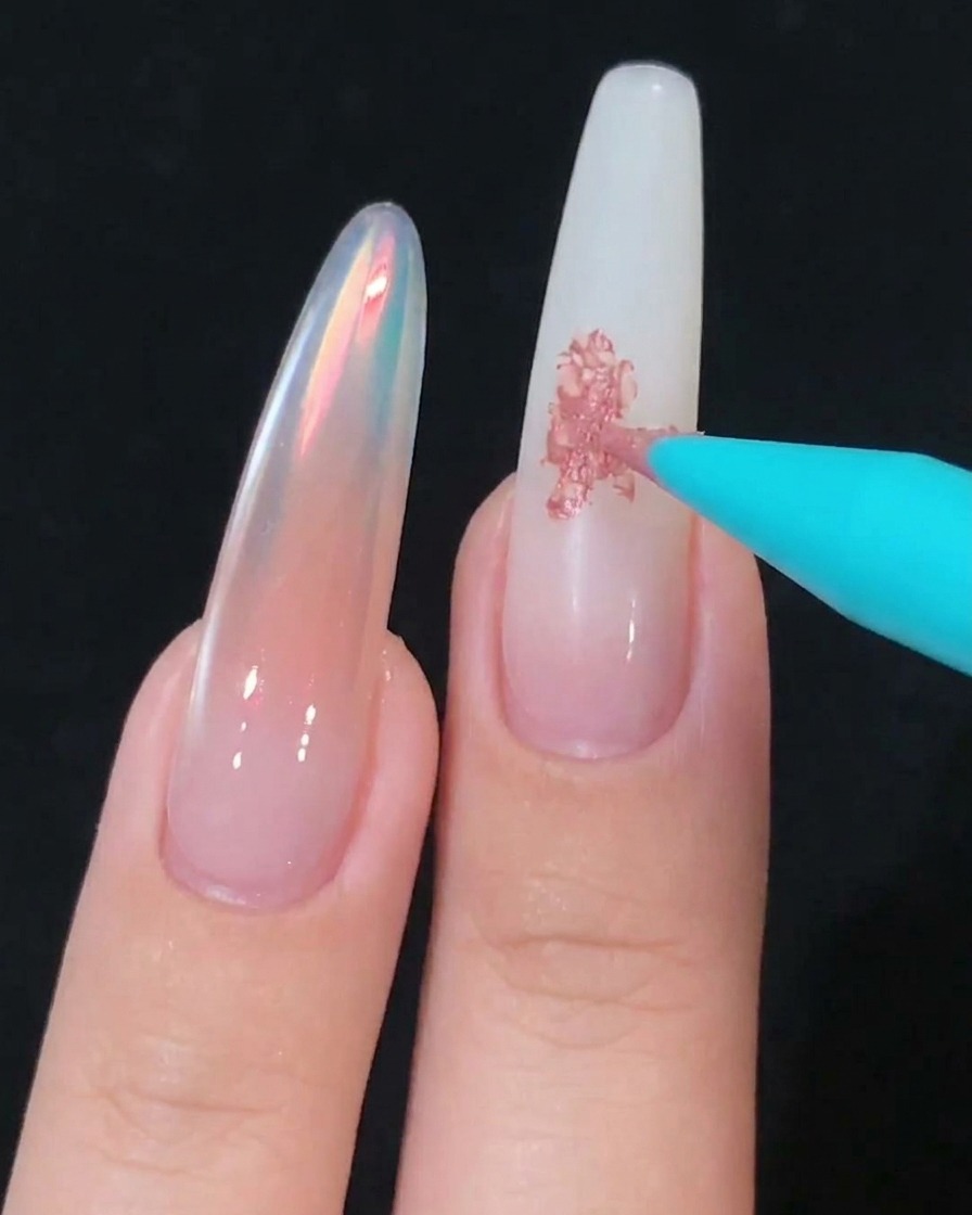 Una herramienta de esponja difuminando suavemente el gel rosa sobre la superficie de la uña.