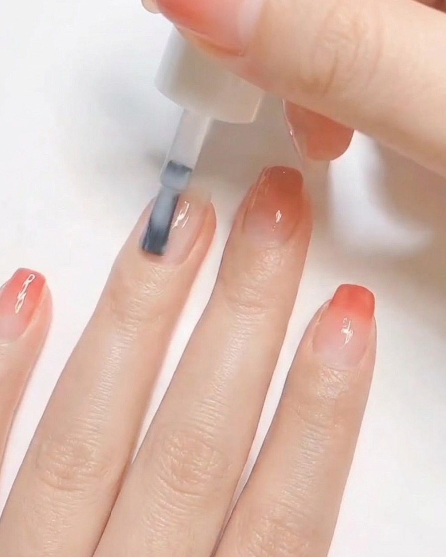Un pincel de uñas aplicando una capa de esmalte blanco opaco a una uña natural preparada.