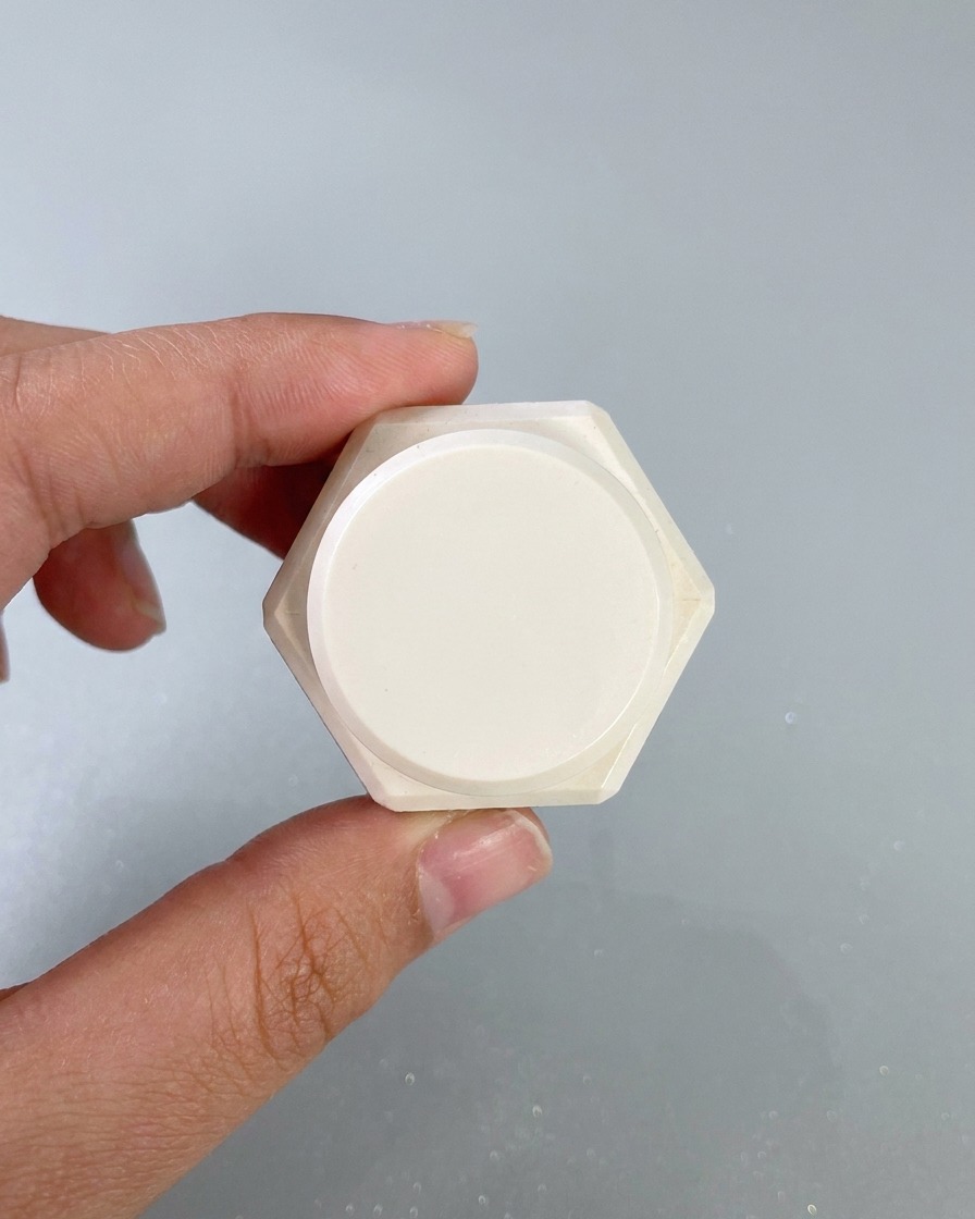 Una esponja de maquillaje aplicando a golpecitos gel de pintura blanca en los bordes de la superficie de una uña pintada.