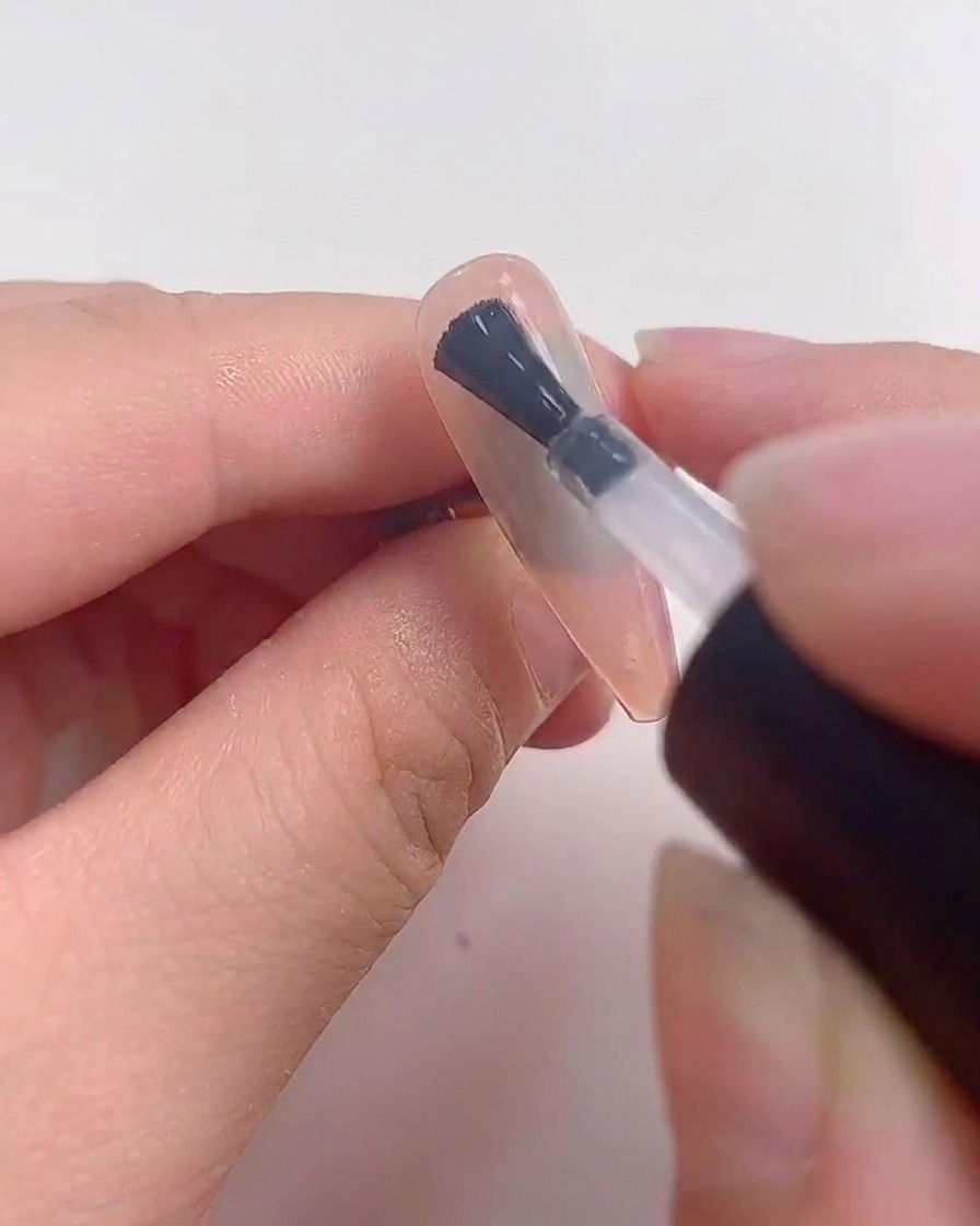 Una uña colocada bajo una lámpara UV o LED durante el proceso de curado.
