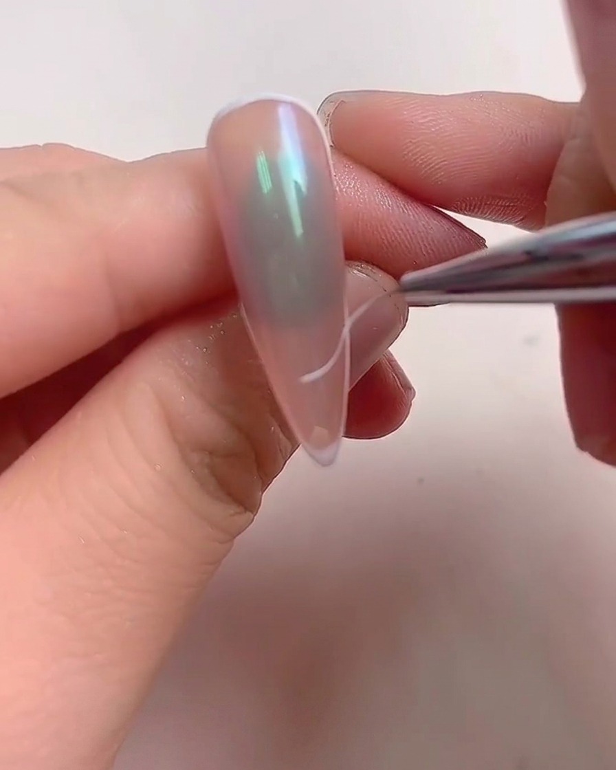 Una mano dentro de una lámpara UV/LED profesional con luz morada iluminando los dedos.