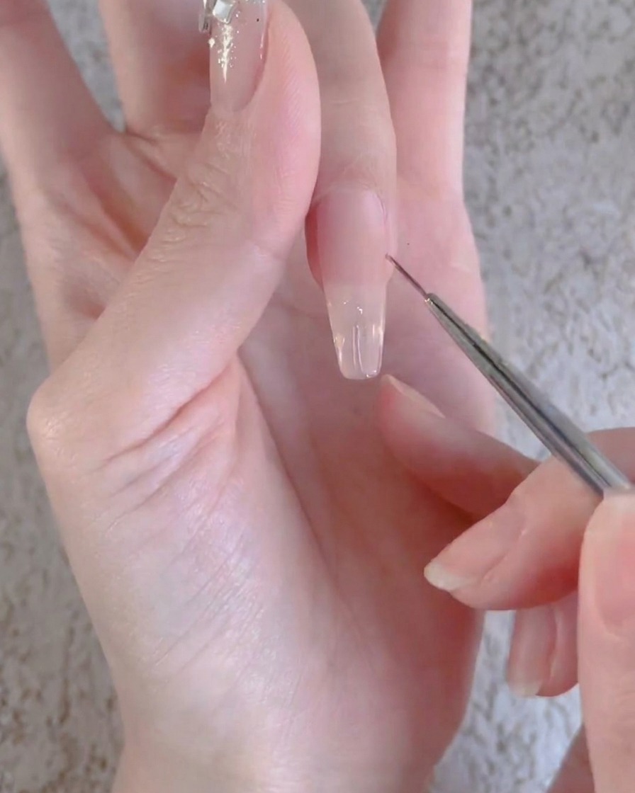 Un dedo con una capa de gel transparente curándose debajo de una lámpara profesional de uñas UV o LED.