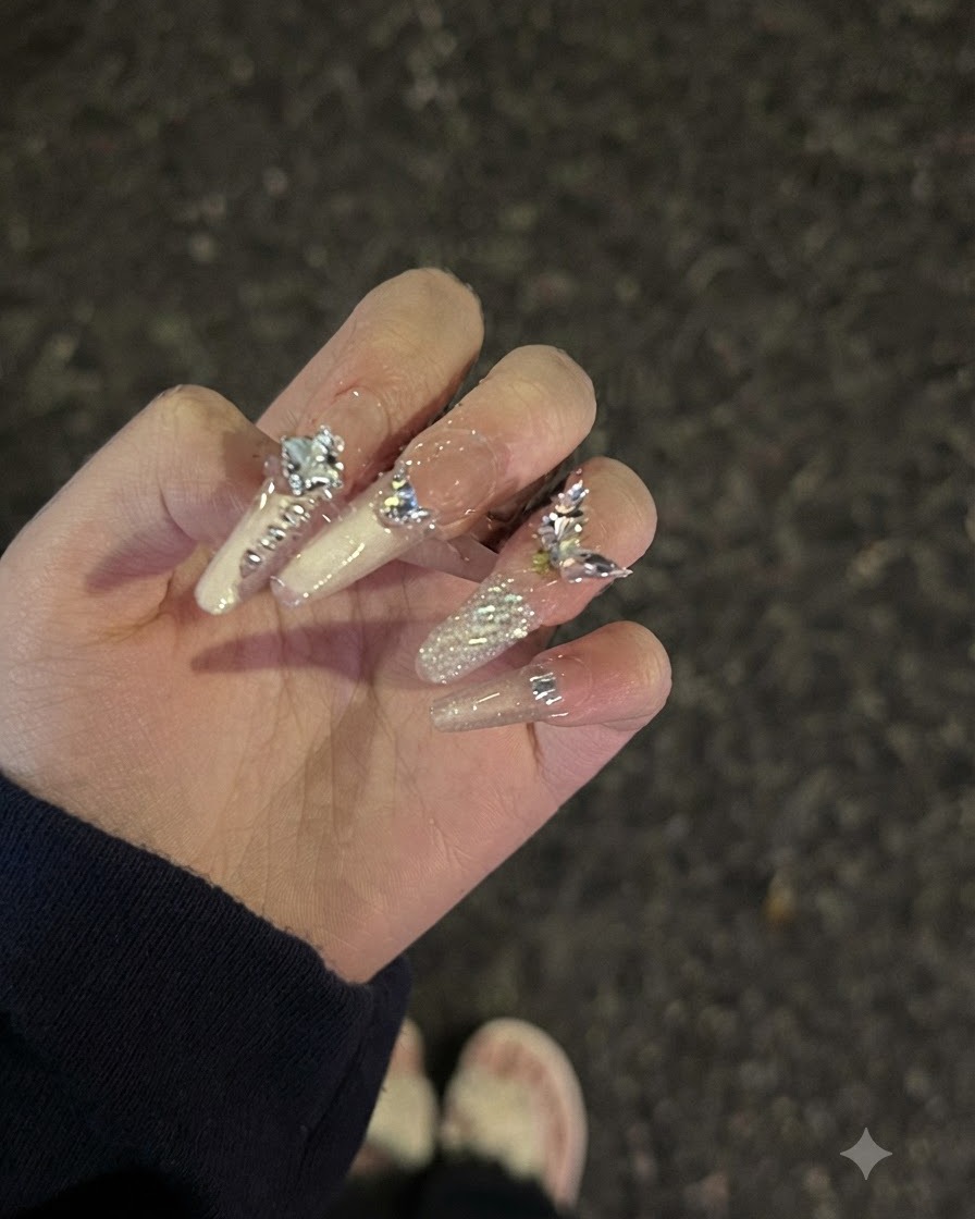 Ajuste en la pose de la mano que muestra el reflejo de la luz y el acabado brillante en las uñas decoradas con pedrería.