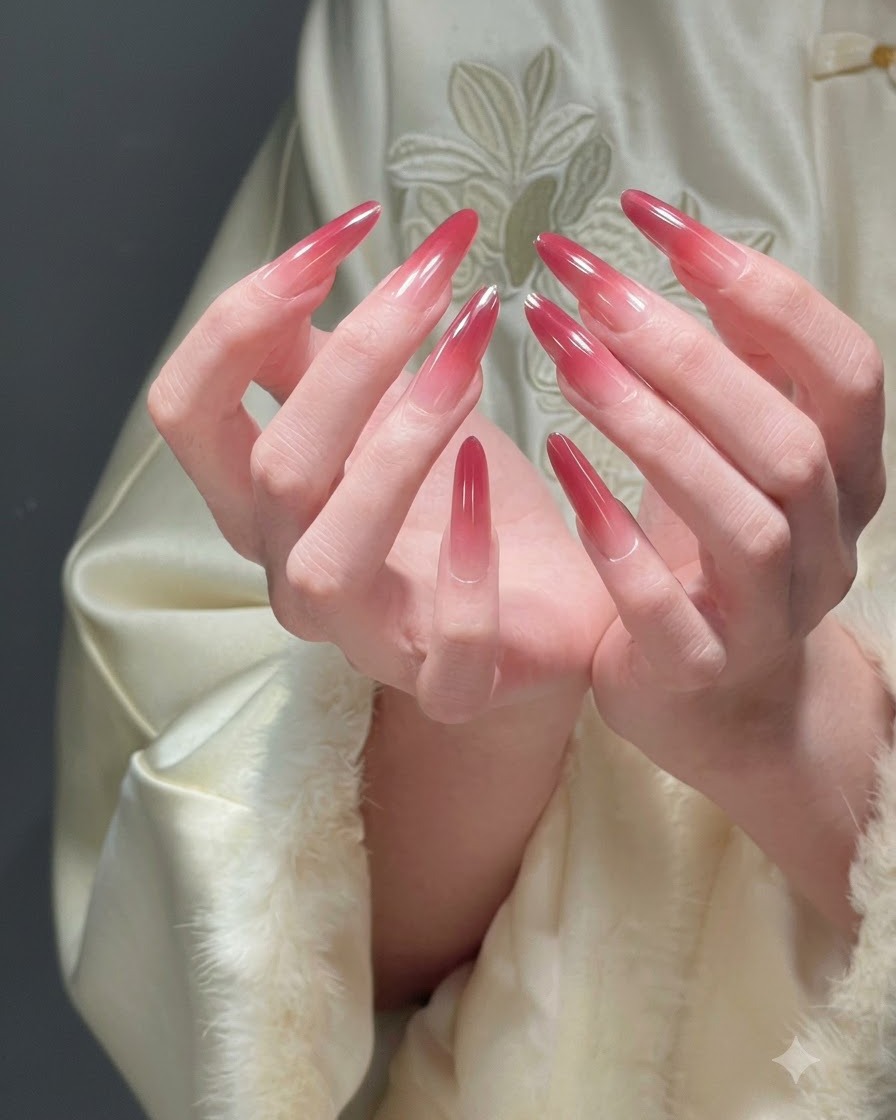 Dos manos juntas en forma de cuenco que presentan todos los dedos para mostrar una manicura ombré roja festiva completa.