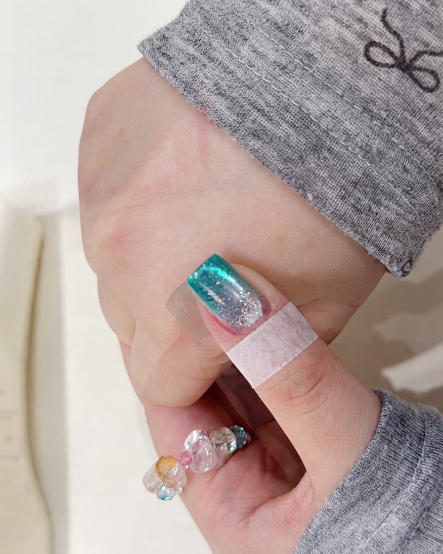 Una mano colocada dentro de una lámpara de uñas UV para curar la capa de pigmento de acuarela recién aplicada.