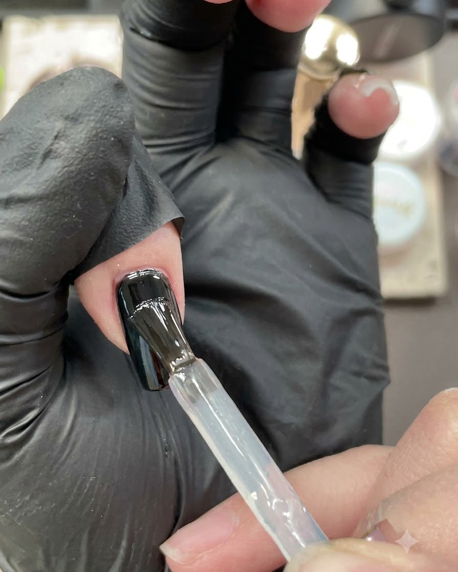Un dedo índice con un top coat brillante curándose bajo una mini lámpara UV/LED.