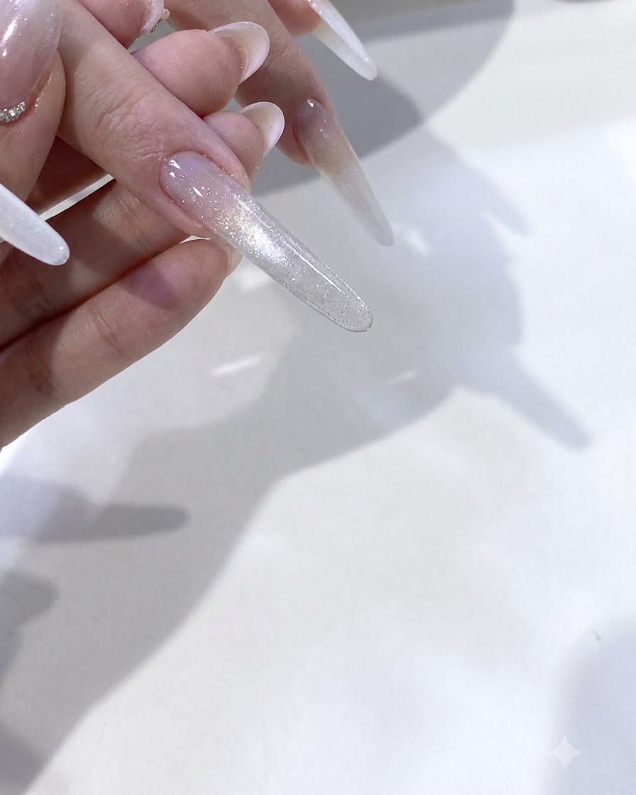 Dientes curándose bajo el brillo rosado de una lámpara de uñas UV/LED.