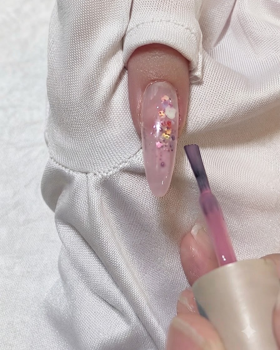 Uña siendo limpiada con una toallita libre de pelusa y limpiador de uñas.