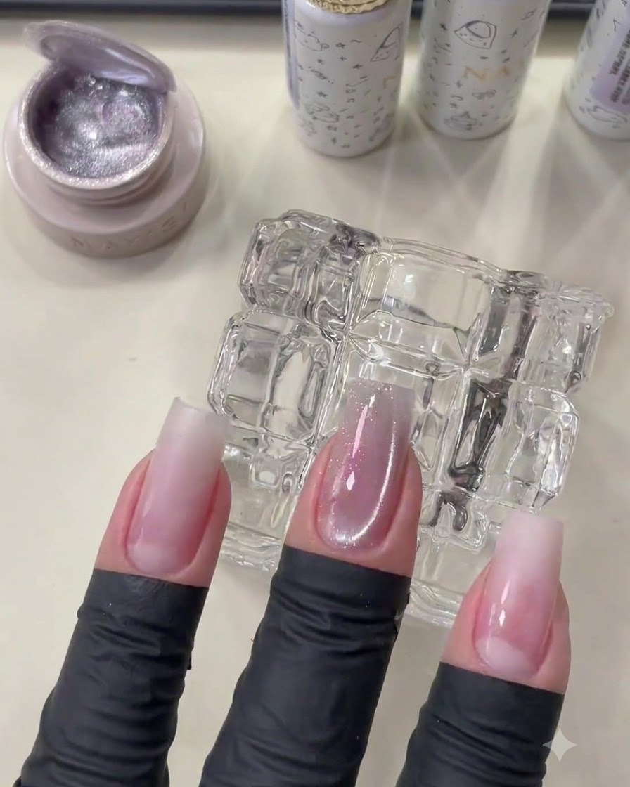 Una mano con manicura que muestra el gel cat eye curado con un brillo suave de cuenta de vidrio.