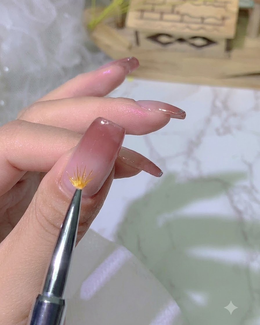 Un pincel de degradado especializado difuminando el borde del esmalte de gel en la superficie de la uña.