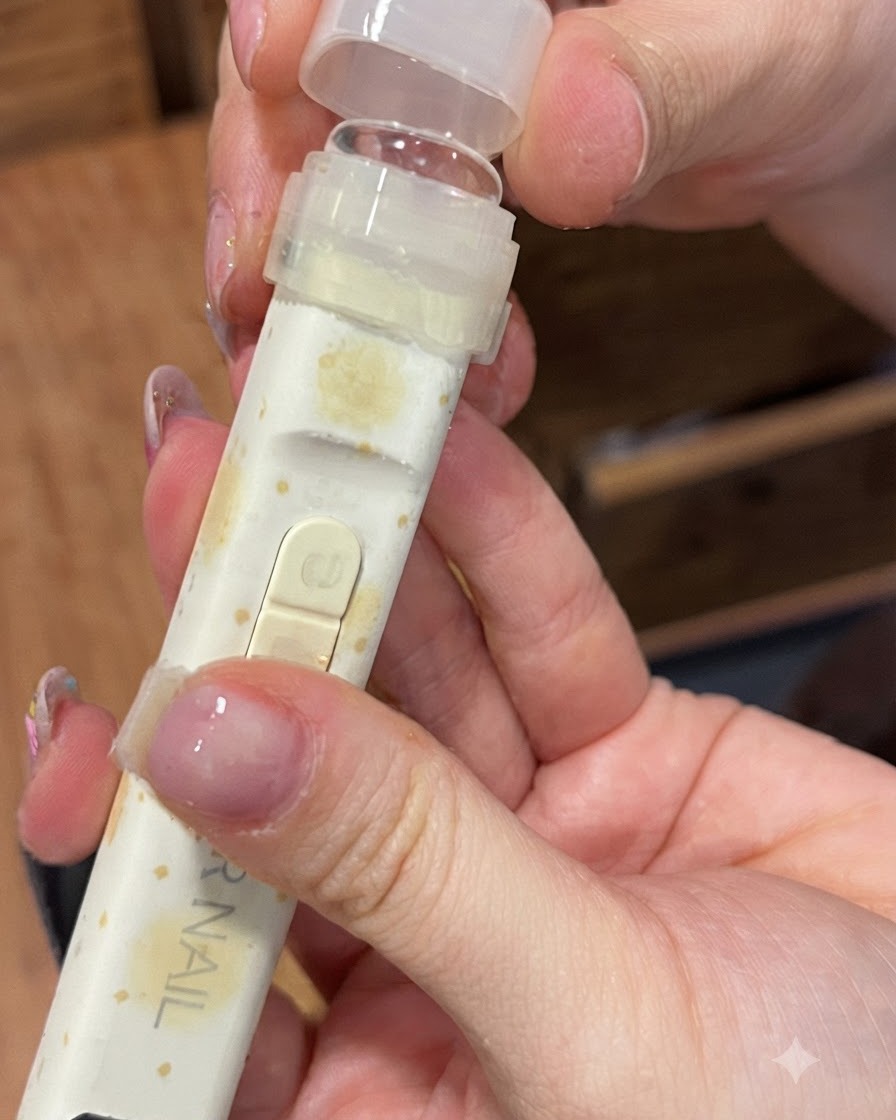 Lámpara de uñas UV/LED portátil equipada con una punta de presión de silicona transparente sostenida sobre un dedo.