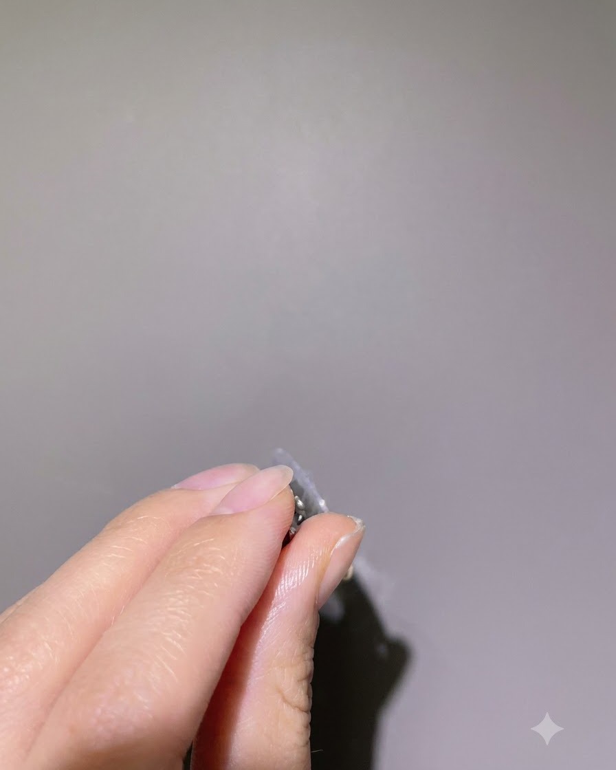 Una vista de perfil lateral de un dedo sostenido boca abajo, permitiendo que el gel constructivo transparente se autonivele.