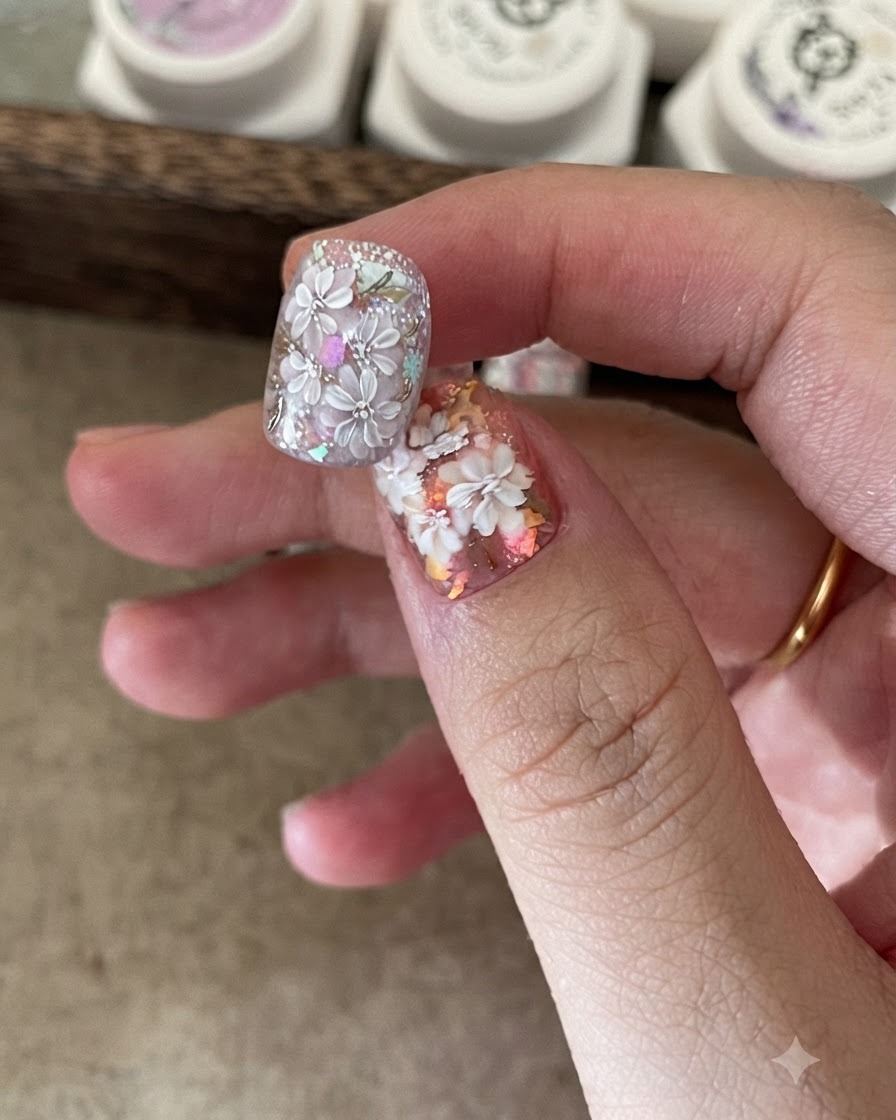 Un pincel pequeño colocando copos de papel holográfico sobre una base de uña pegajosa.