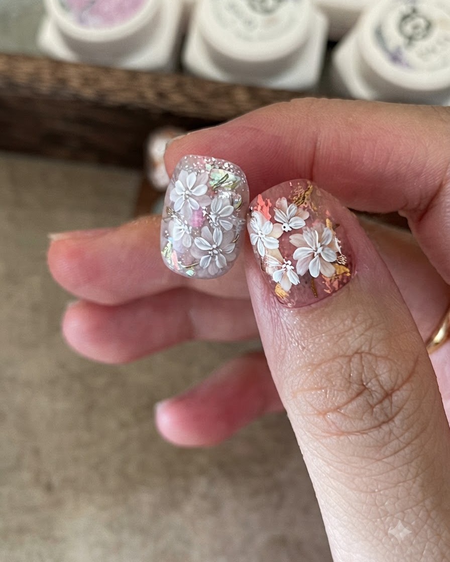 Aplicando una capa base transparente sobre el diseño de uñas blooming ya curado.