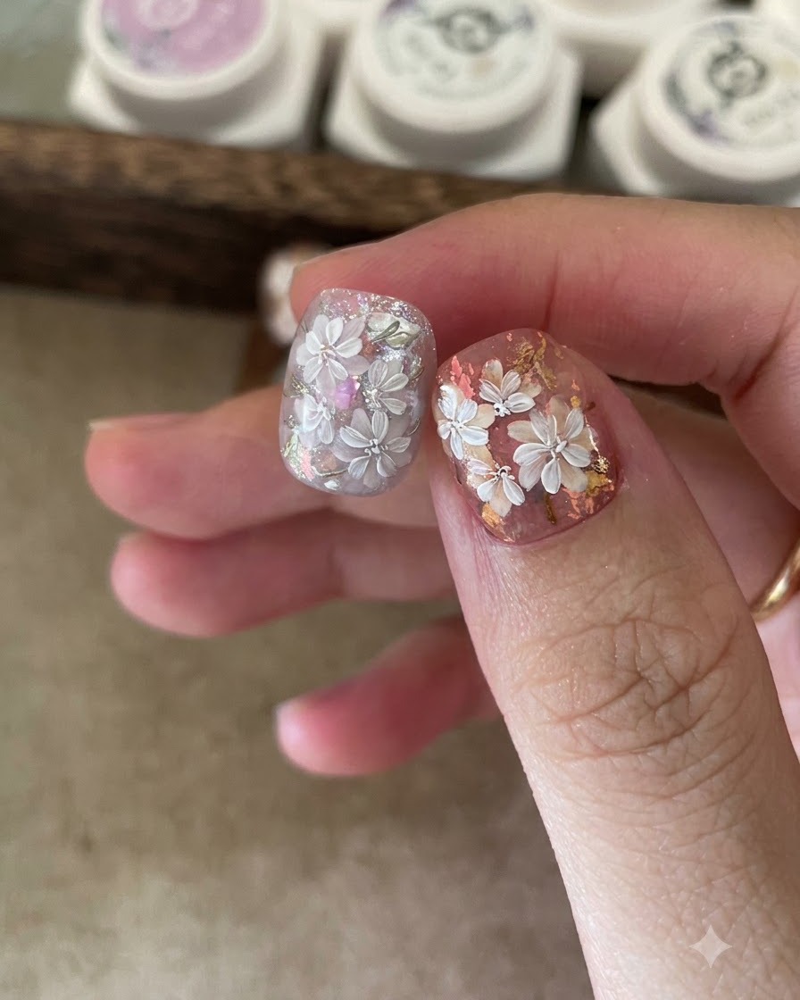 Un primer plano de unas pinzas colocando copos holográficos sobre una base de gel pegajosa en una uña.