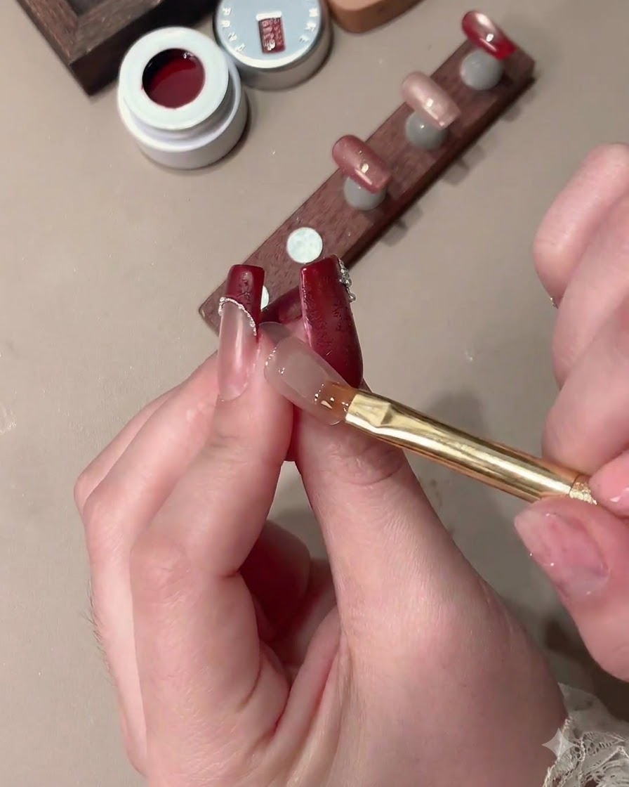Un imán moldeando gel de ojo de gato en una uña para crear un efecto de luz amplia con un espacio transparente para la punta francesa.