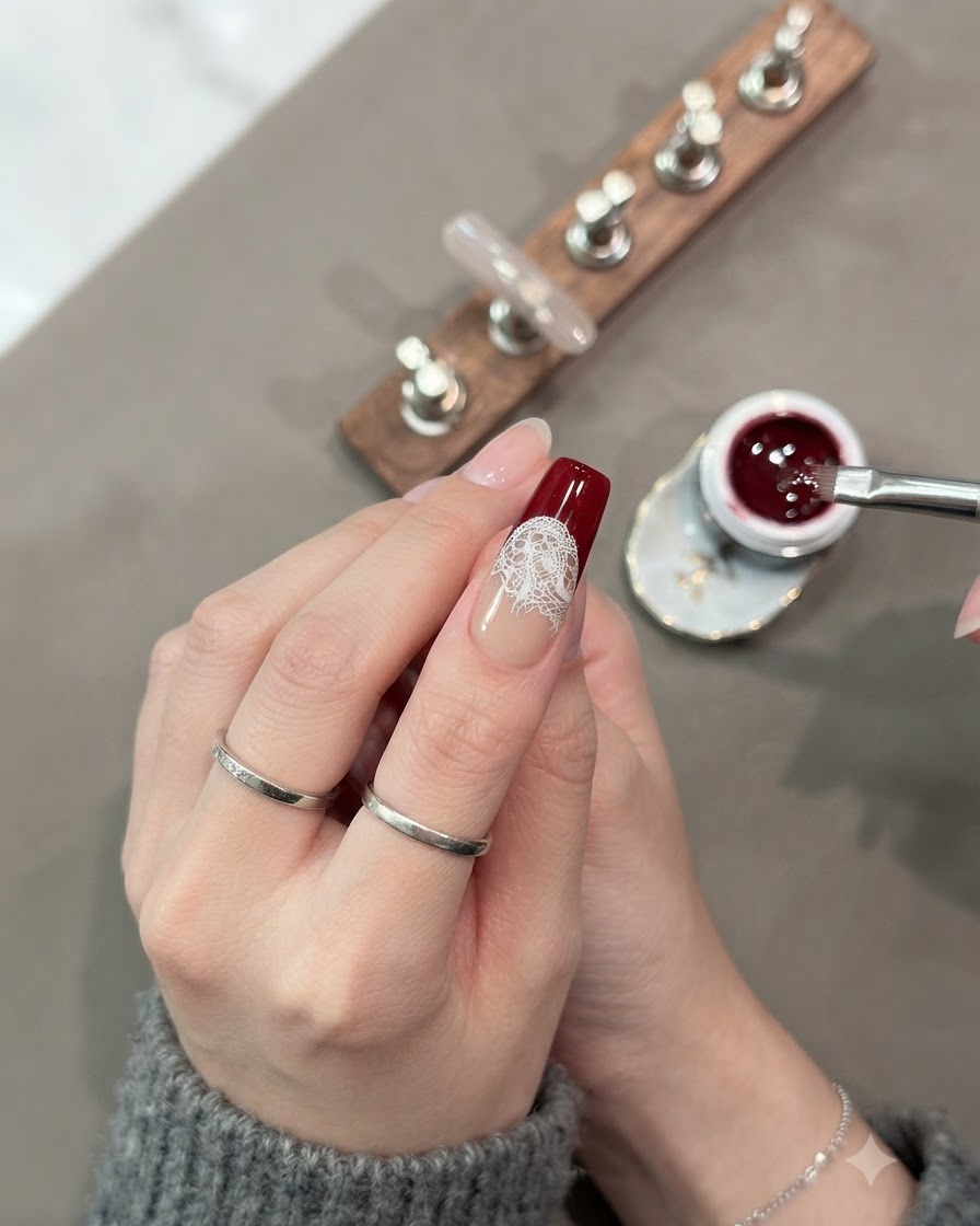 Un pincel rellenando completamente la sección inferior de la punta de la uña con gel ojo de gato rojo oscuro.
