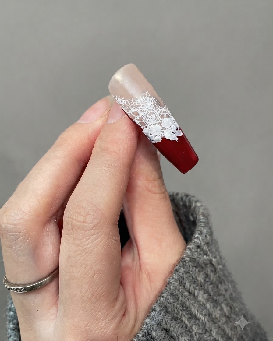 Un primer plano de una uña que muestra pequeños detalles de hojas blancas pintadas alrededor de los bordes de las flores de rosas blancas.