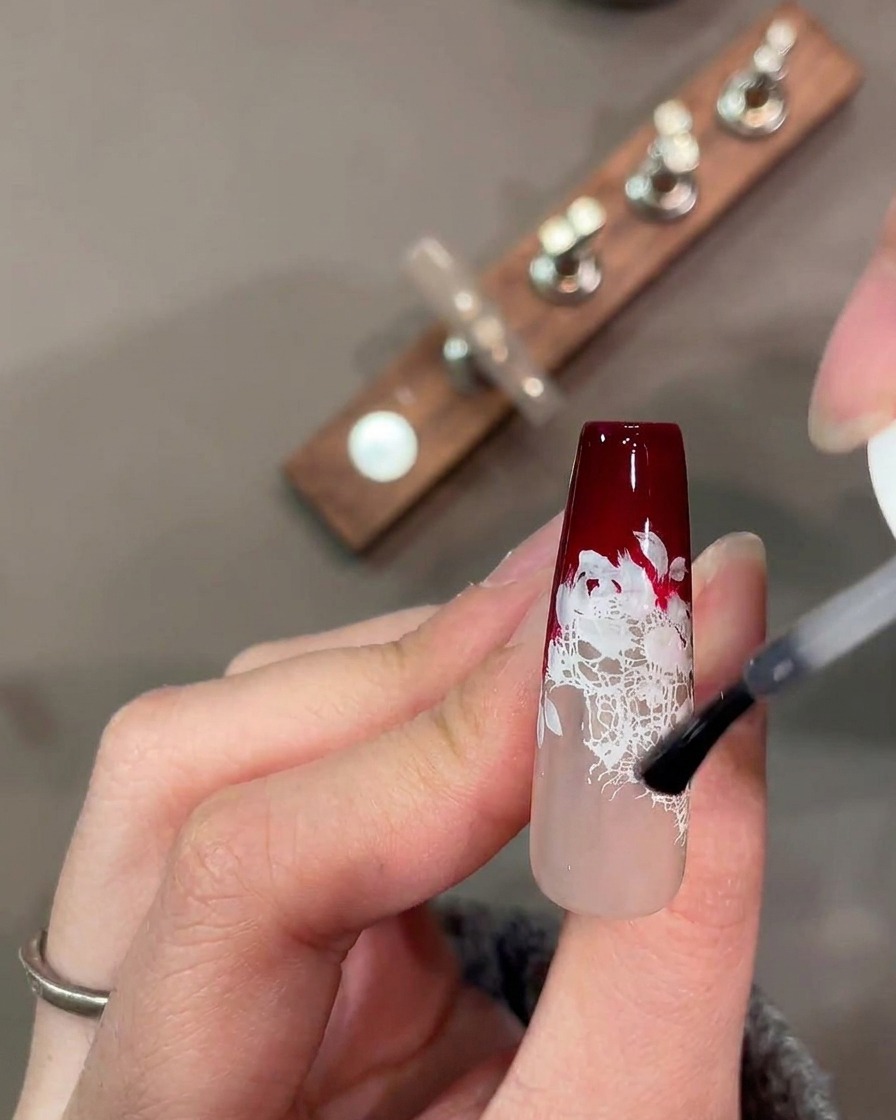 Una paleta de acuarela con pigmentos mezclados en rojo, verde y rosa para arte en uñas.