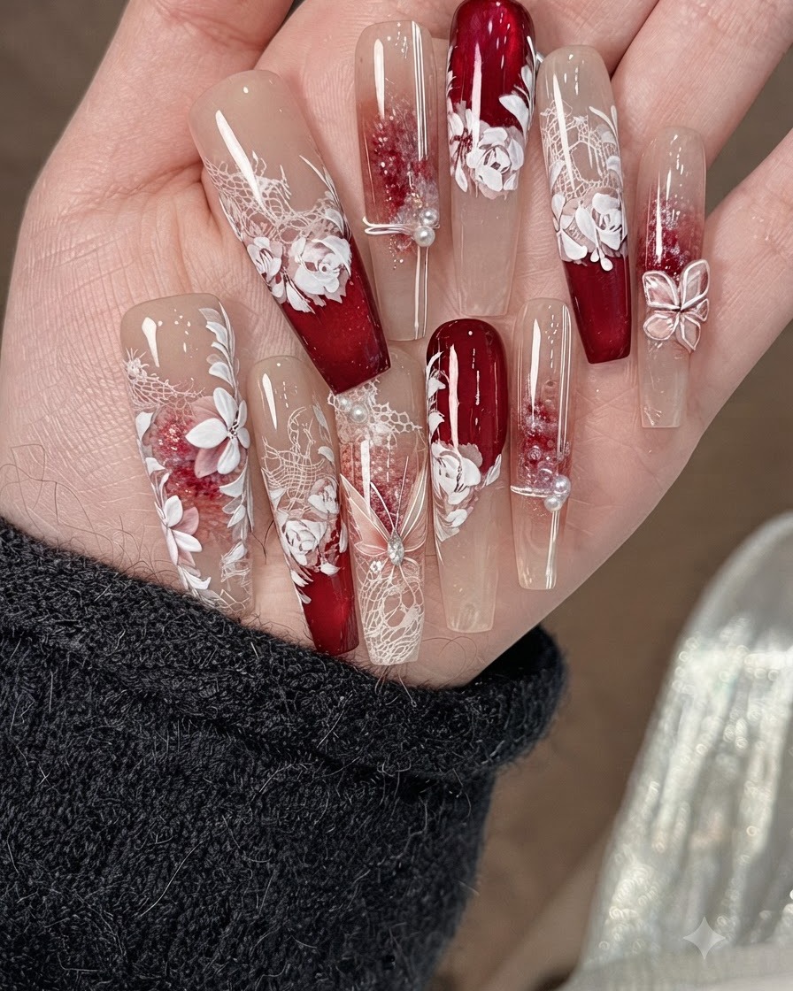 Un pequeño pincel de arte en uñas difuminando los bordes del líquido de halo de acuarela rosa y blanca sobre una base de uña beige.