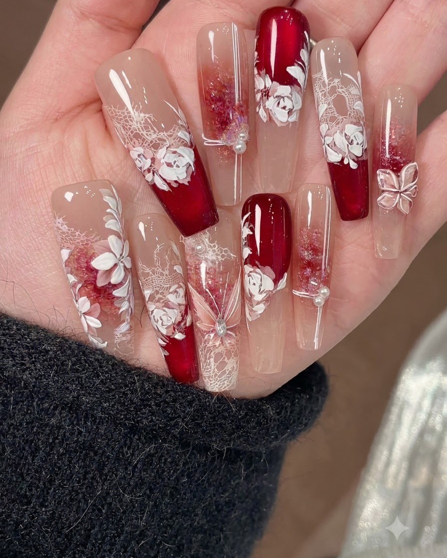 Un pincel fino de arte en uñas dibujando líneas de acento finas encima de las decoraciones de uñas florales blancas.