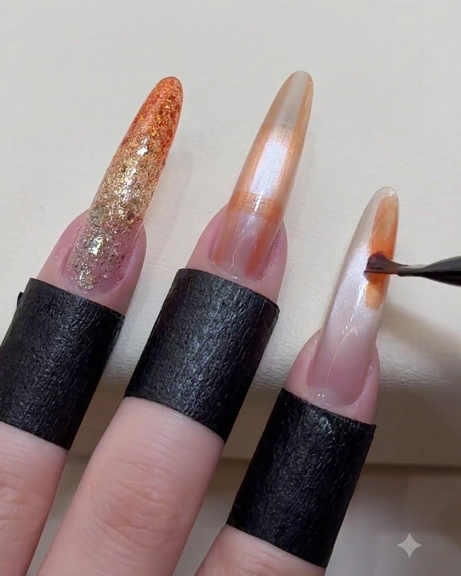 Un pincel para arte de uñas aplicando bloques de color abstractos y aleatorios sobre la superficie de una uña en forma de almendra.