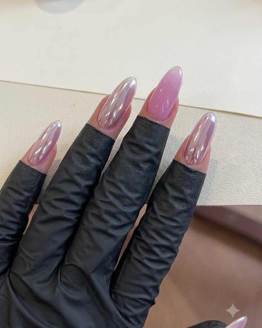 Una mano con uñas de gel morado terminadas descansando bajo iluminación durante la etapa de curado.
