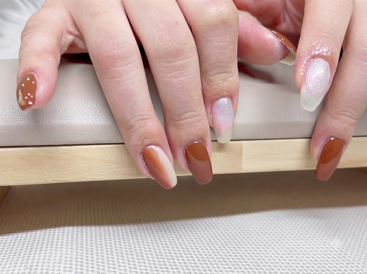 Disparo macro detallado de uñas de gel caramelo y ámbar terminadas que reflejan la luz bajo un top coat brillante.
