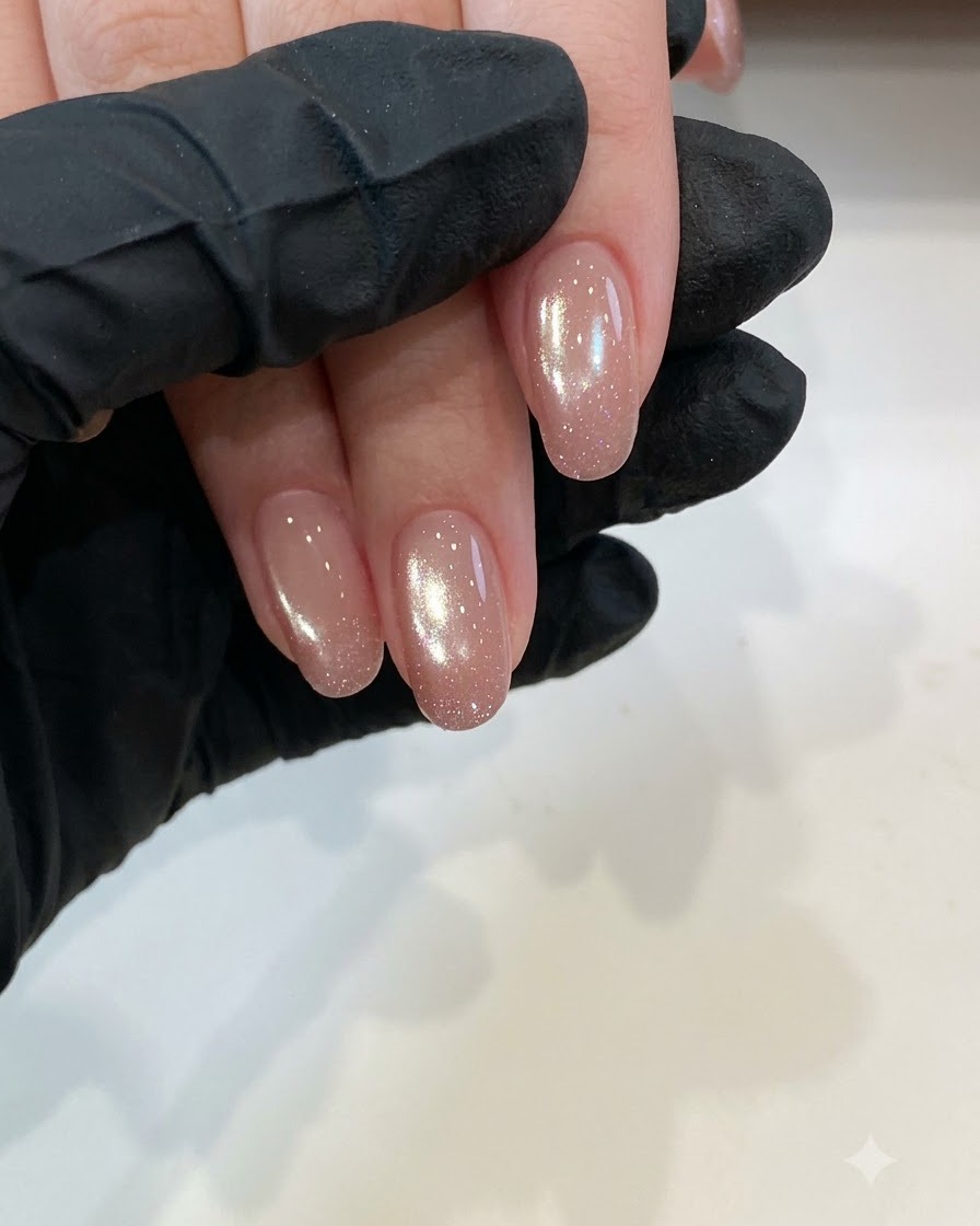 Primer plano de uñas naturales cortas y limpias, listas para la preparación con base coat bajo iluminación de estudio.