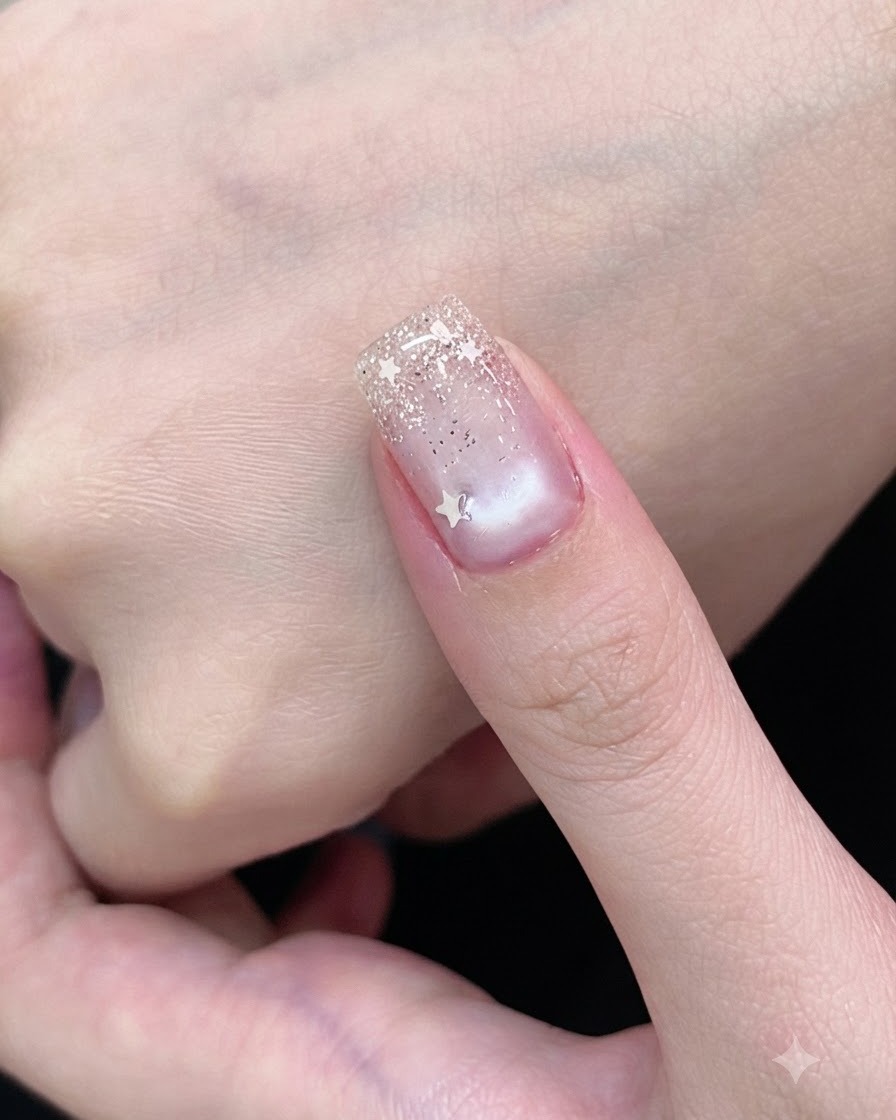 Un pincel de gel cubriendo una uña con un esmalte de gel ojo de gato blanco translúcido.