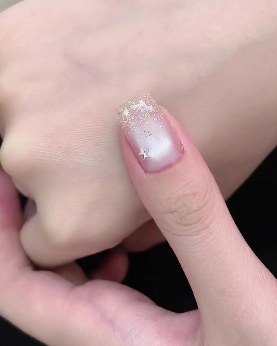 Una mano descansando bajo una lámpara de uñas UV o LED durante la etapa final de curado de una manicura.