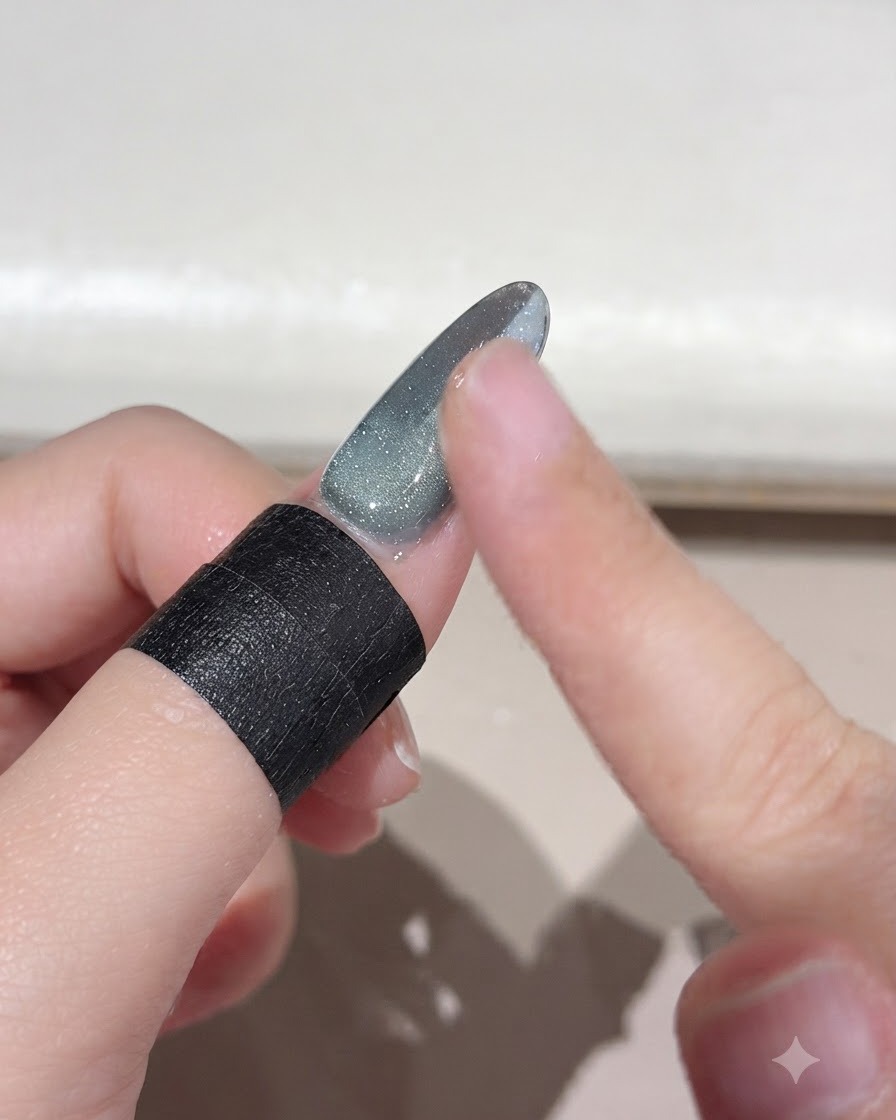 Un dedo cepillando el exceso de polvo mágico suelto de la superficie de una uña con degradado.