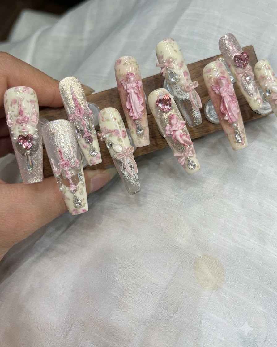 Pincel de detalles fino aplicando pequeñas partículas de gel de purpurina en el centro de una uña decorada.