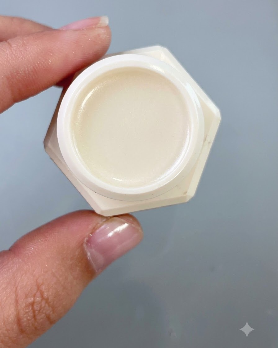Un primer plano de un pequeño tarro que contiene gel de transferencia, sostenido contra un fondo gris neutro.
