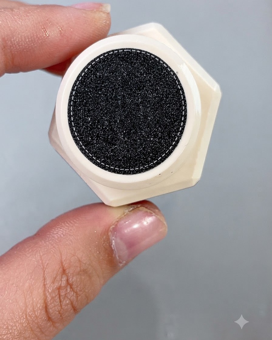 Un pincel de esmalte de uñas que aplica un gel ojo de gato melón brillante uniformemente sobre una punta de uña postiza.
