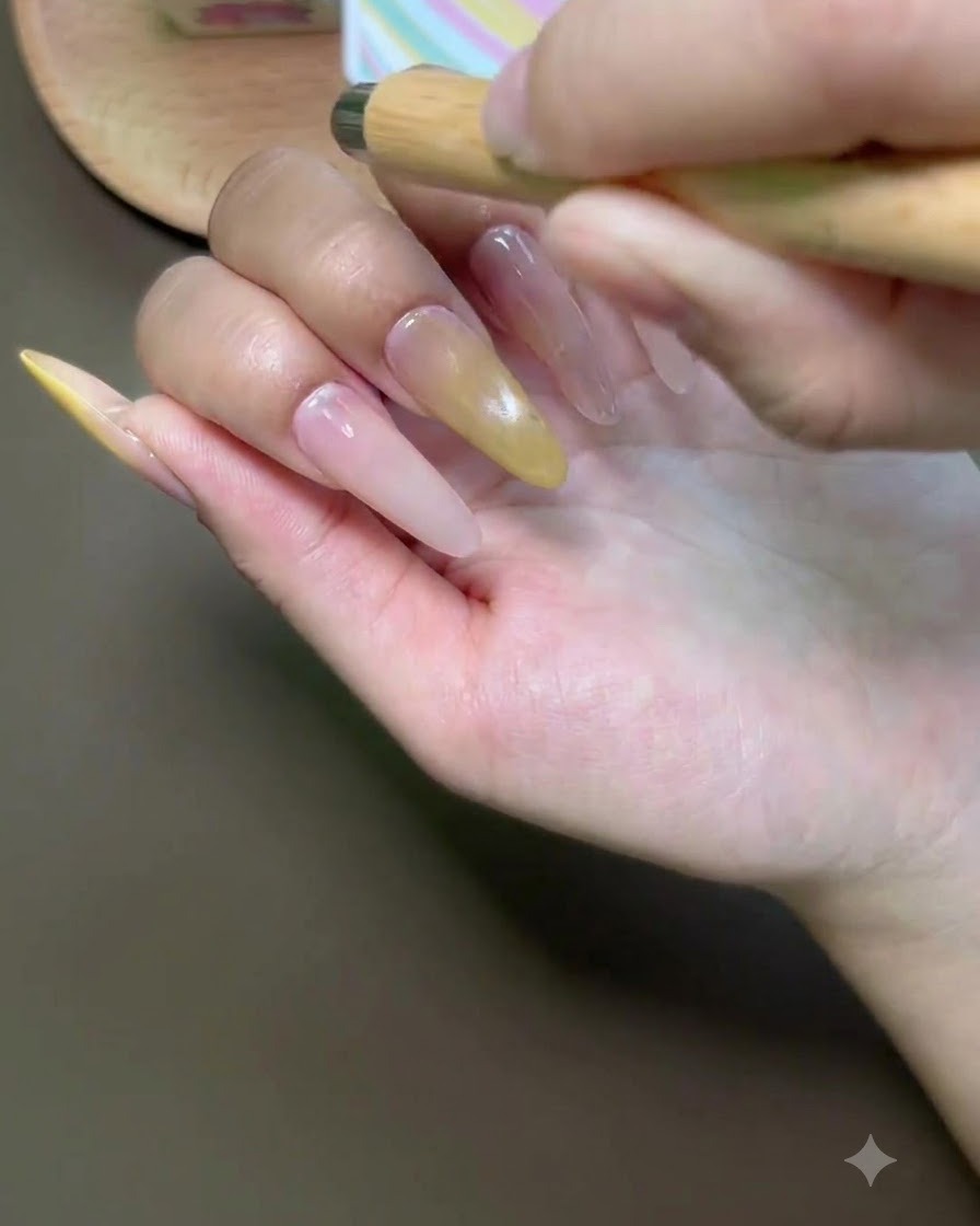 Un pincel aplicando esmalte de gel ojo de gato en la uña del dedo índice.