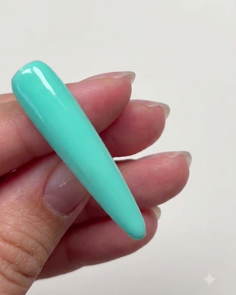 Una extensión de uña larga stiletto completamente cubierta con una capa suave de gel de color verde menta.