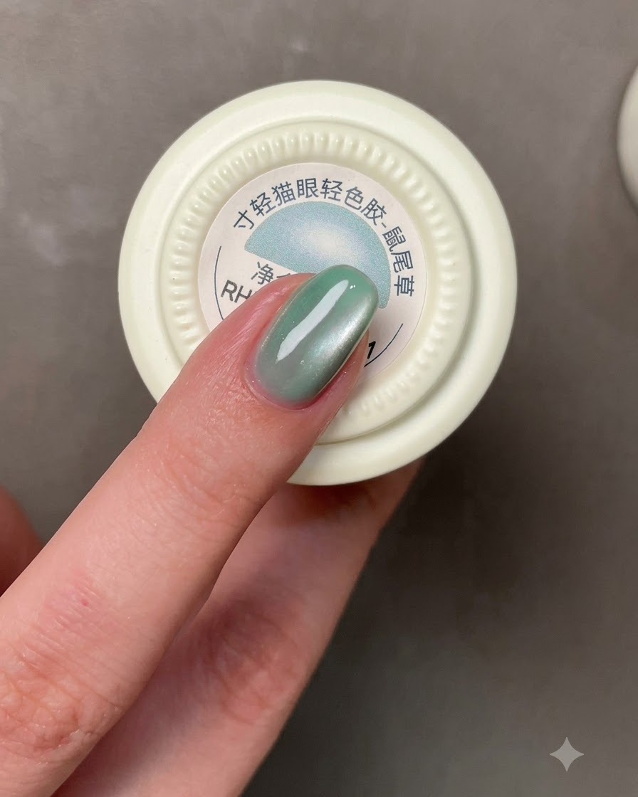 Un pincel aplicando un esmalte de gel azul grisáceo sobre una uña.
