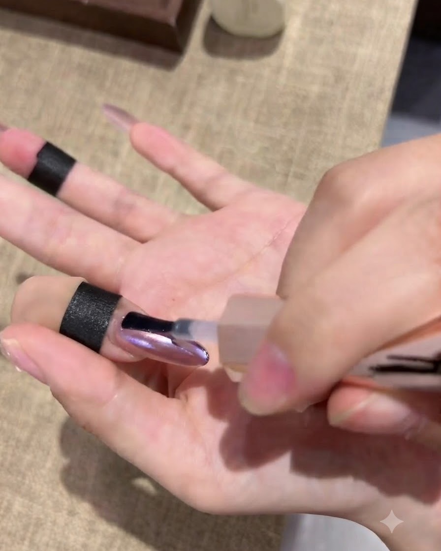 Una mano descansando dentro de una lámpara de curado de uñas con las yemas de los dedos iluminadas bajo la luz.