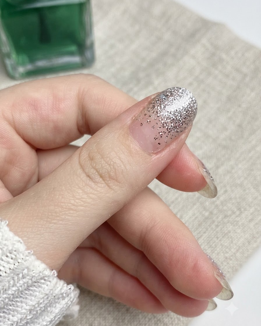Una lima de uñas moviéndose hacia abajo contra el borde de una uña del pulgar.