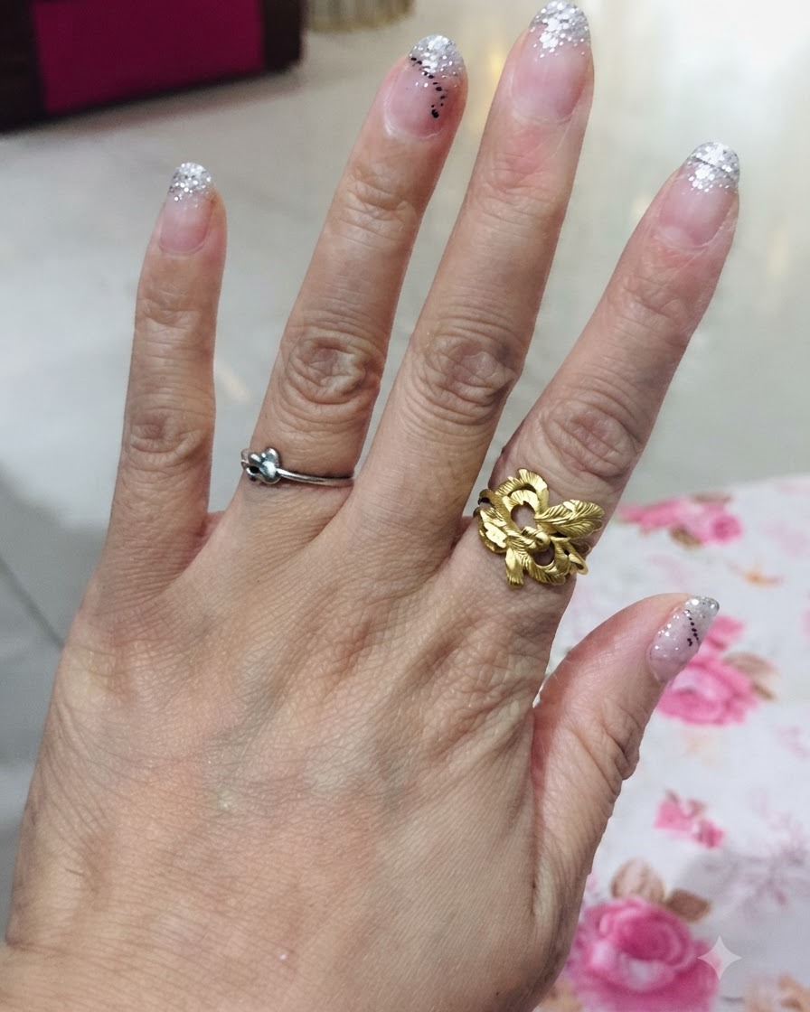 Una vista cenital de una mano que muestra los cinco dedos con un diseño de degradado de brillo plateado.