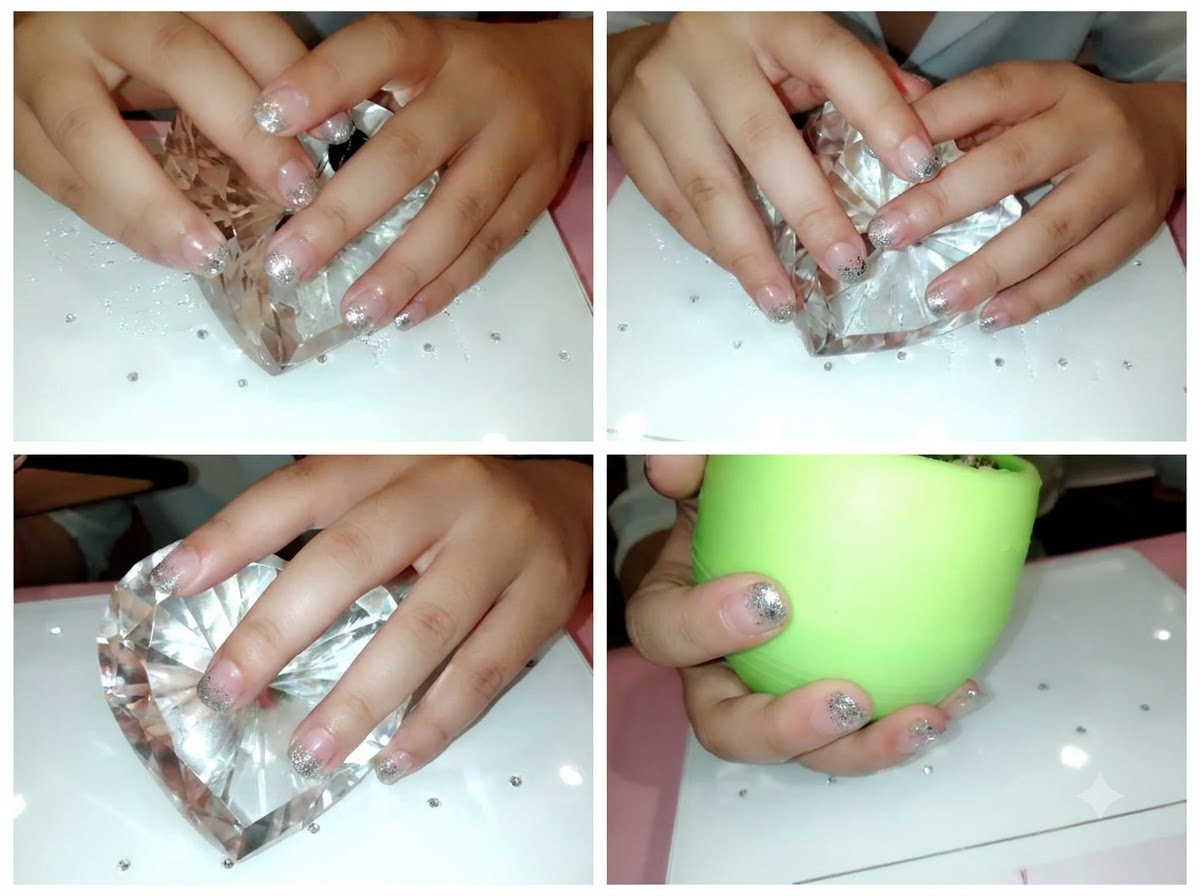 Un primer plano de unas manos con uñas naturales preparadas descansando sobre un expositor de corazones de cristal.