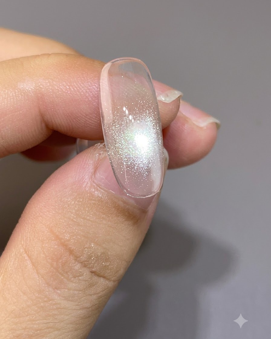 Un imán posicionado muy cerca sobre una uña, formando un punto focal cat-eye cerrado y brillante.