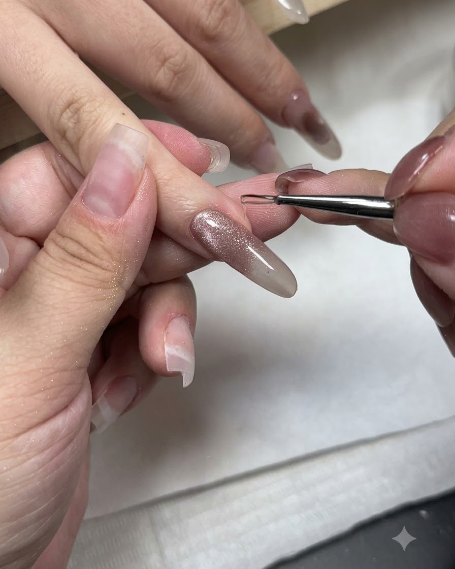 Un pincel fino de nail art aplicando gel de estilo sin capa en la punta de una uña con gel ojo de gato.