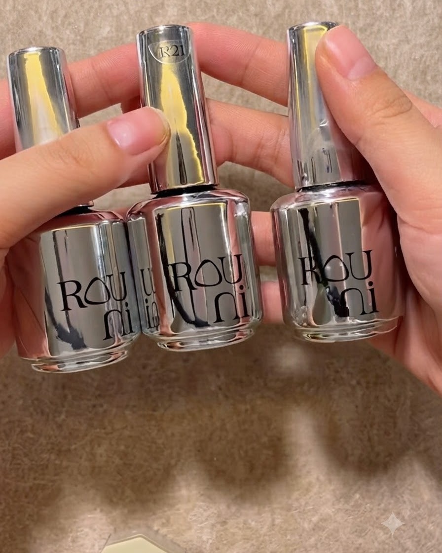 Tres frascos de gel plateados y brillantes alineados ordenadamente sobre una superficie neutral.