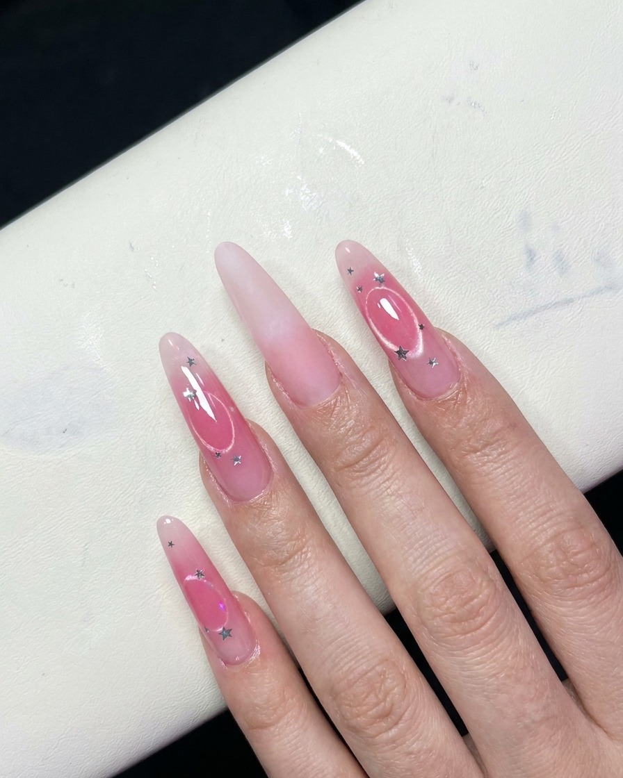 Vista de cerca de dedos que muestran un efecto degradado de blush rosado en el centro de las uñas.