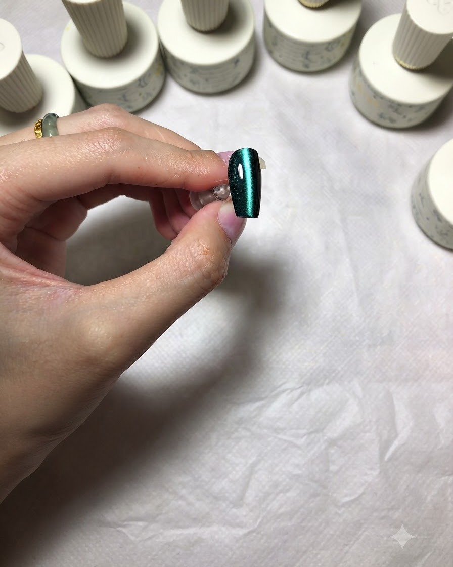 Una uña verde ojo de gato terminada que muestra una línea nítida y centrada de luz brillante.